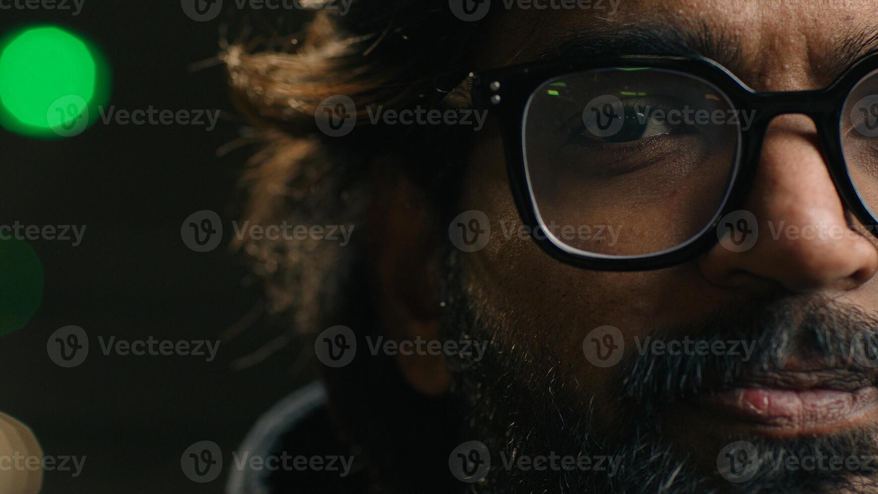 Close up portrait half male serious face Indian man in eyeglasses looking at camera at parking lot underground Arabian male in glasses vision eyesight problem laser correction. Headshot homeless guy photo
