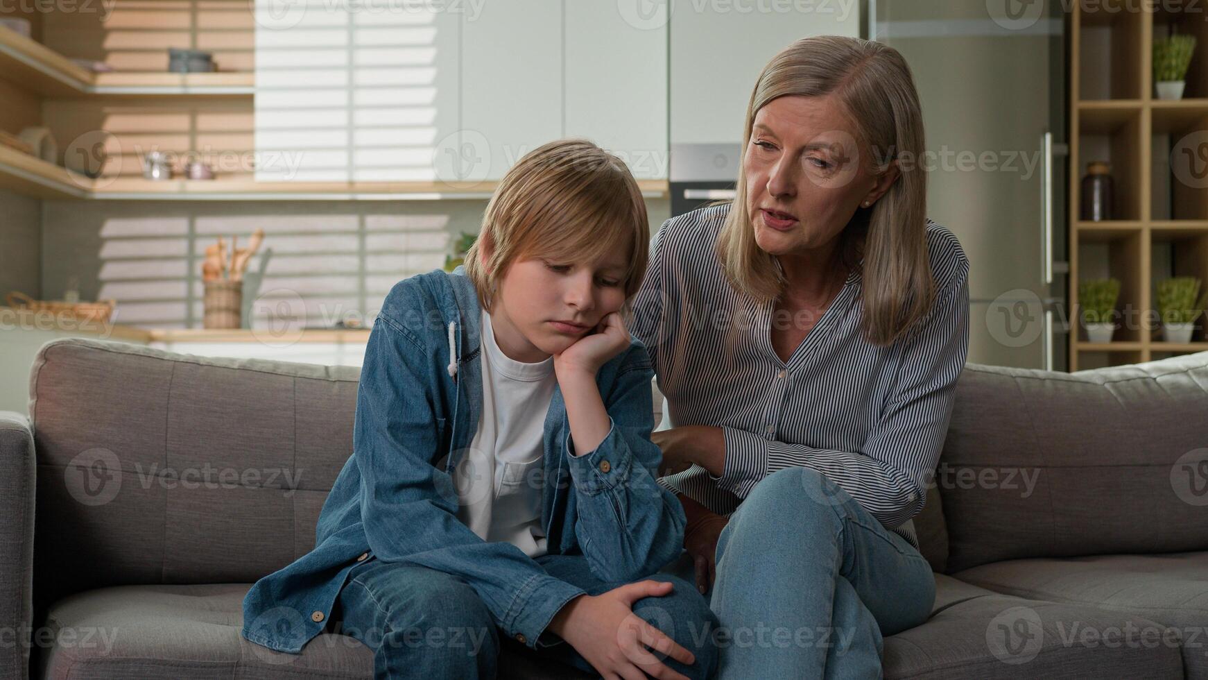 Strict angry elderly senior Caucasian woman grandmother punishing disobedient lazy offended grandson at home scolding grandchild kid boy due to bad behavior discipline family conflict explaining rules photo