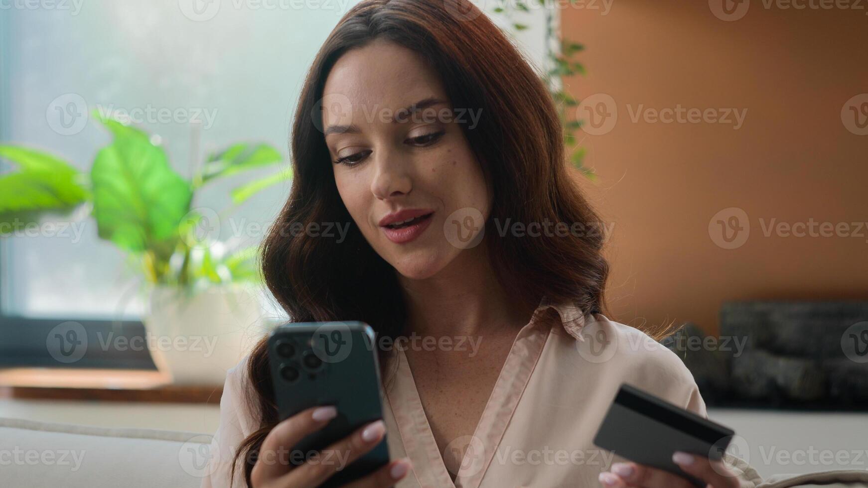 Satisfied Caucasian woman credit card holder use mobile app bank phone to pay online buy consumer girl at home buying goods order ecommerce websites booking food delivery safe transaction e-bank photo