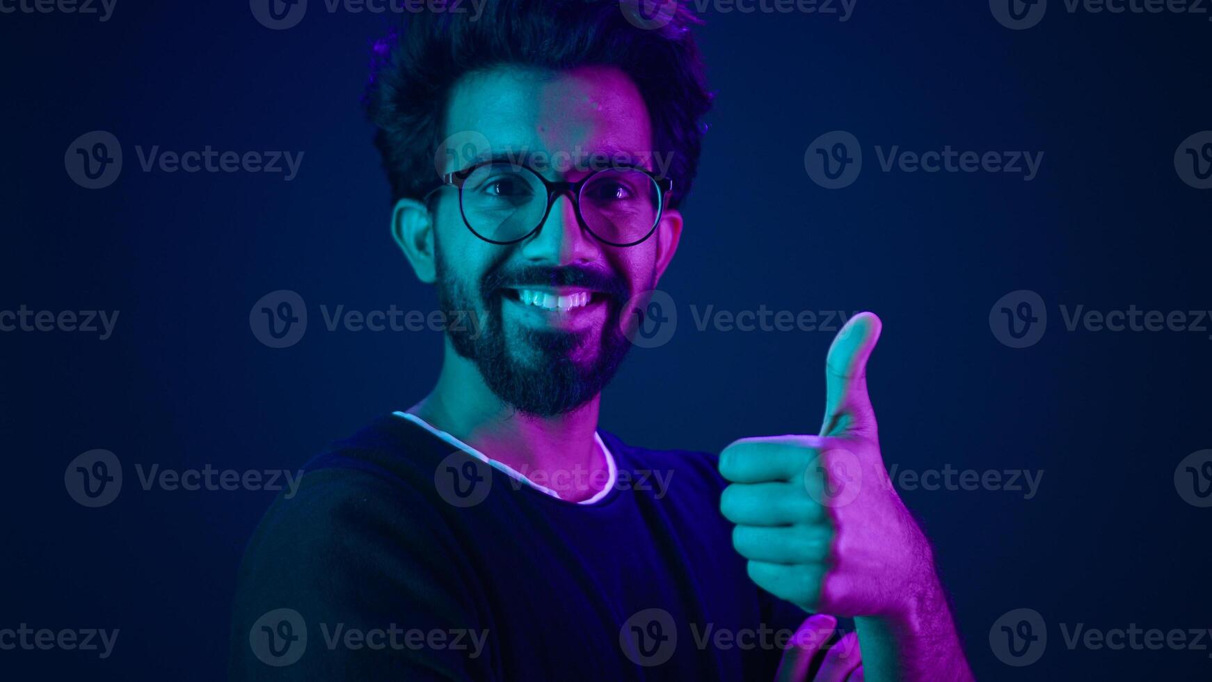 Ultraviolet neon background Arabian smiling happy man hi-tech internet technology worker coding male coder computer hacker smile showing thumb up like agree recommend future modern high-tech software photo