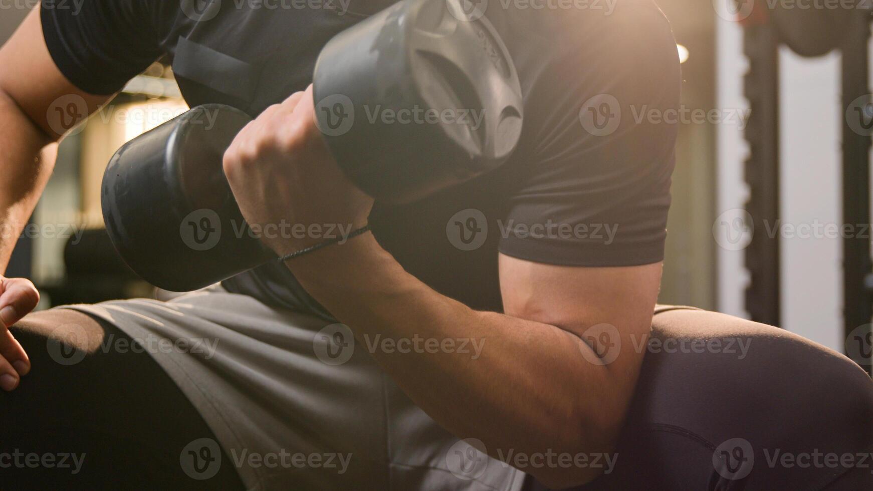 Close up moving shot strong athletic African American ethnic man guy in gym doing sport exercise with dumb-bell curl biceps workout male sportsman athlete hands arms lifting up heavy dumbbell weights photo