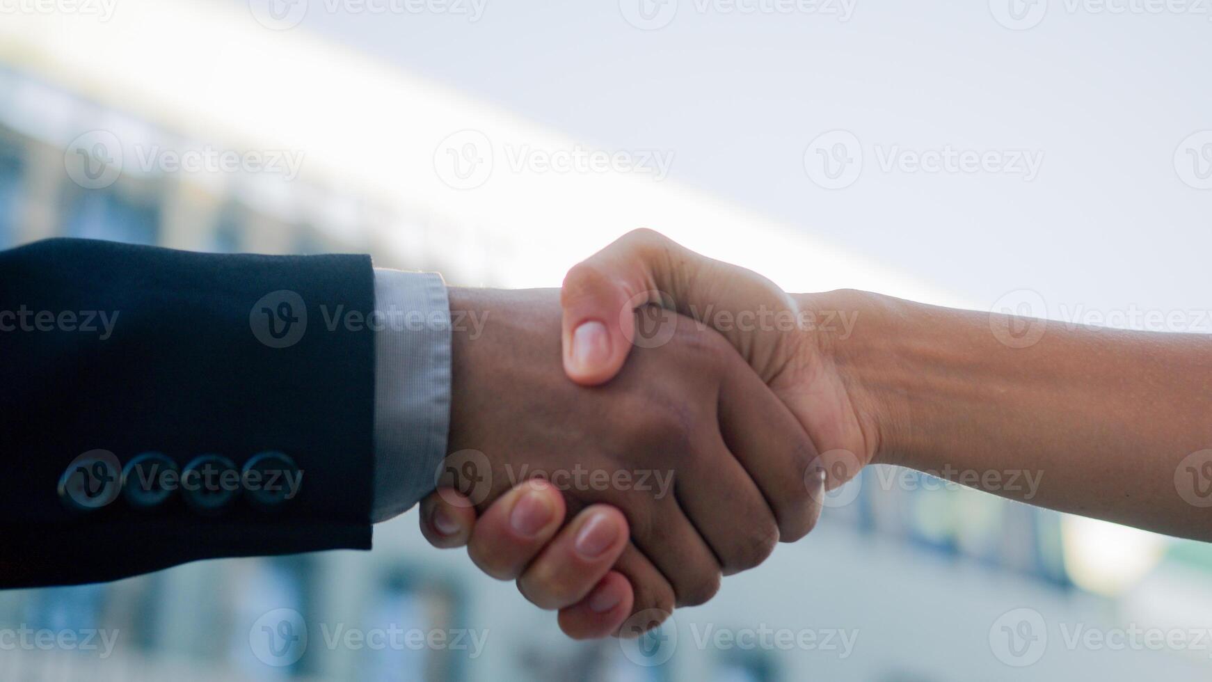 Closeup two people diverse multiracial man woman shake hands conclude successful contract agreement support partnership cooperation businessman and businesswoman greet on street business handshaking photo