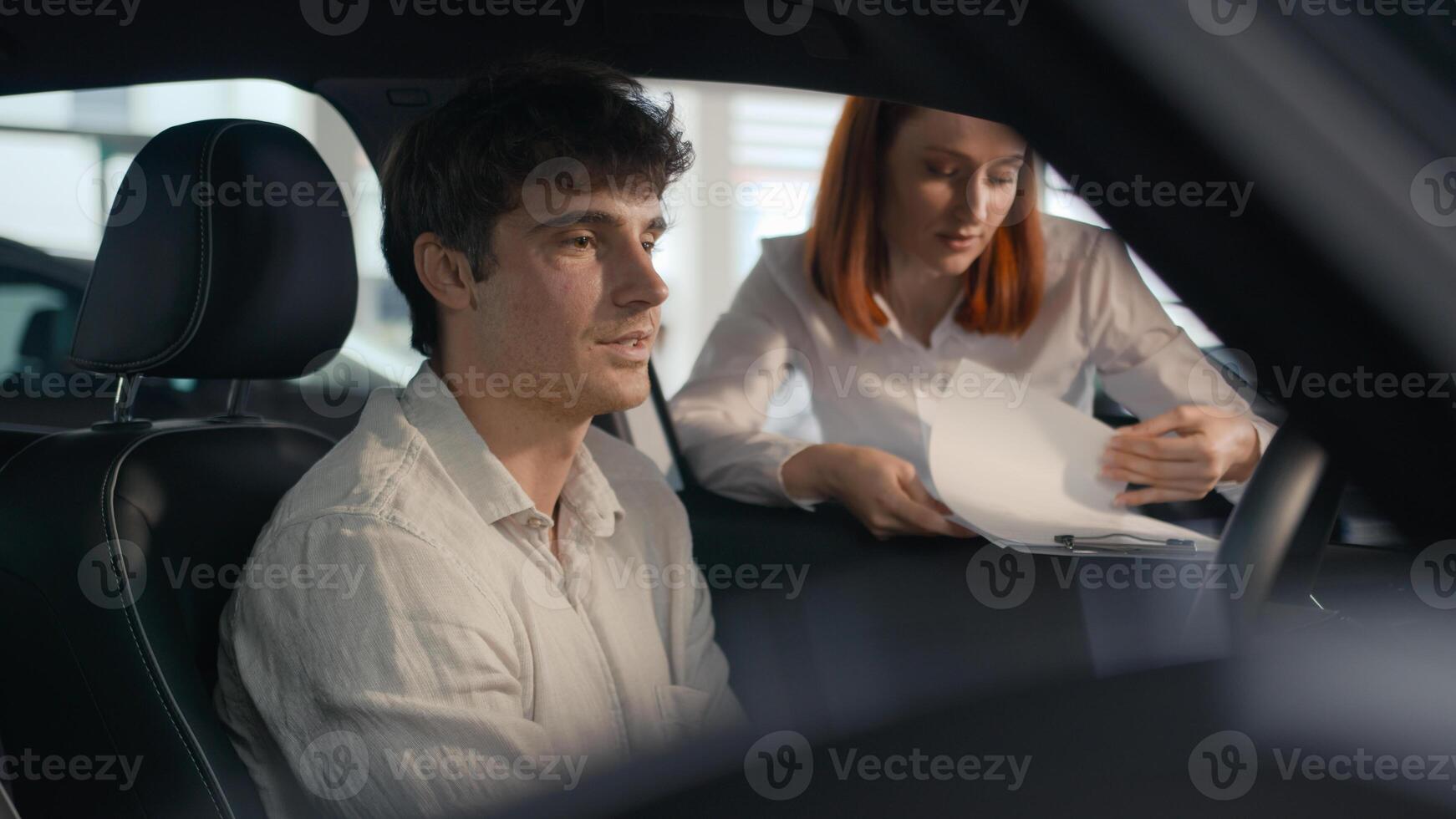 Caucasian seller woman female automobile salon manager trader saleswoman consult client male buyer man helping businessman choose auto explain trade new car to customer male sit inside vehicle rent photo