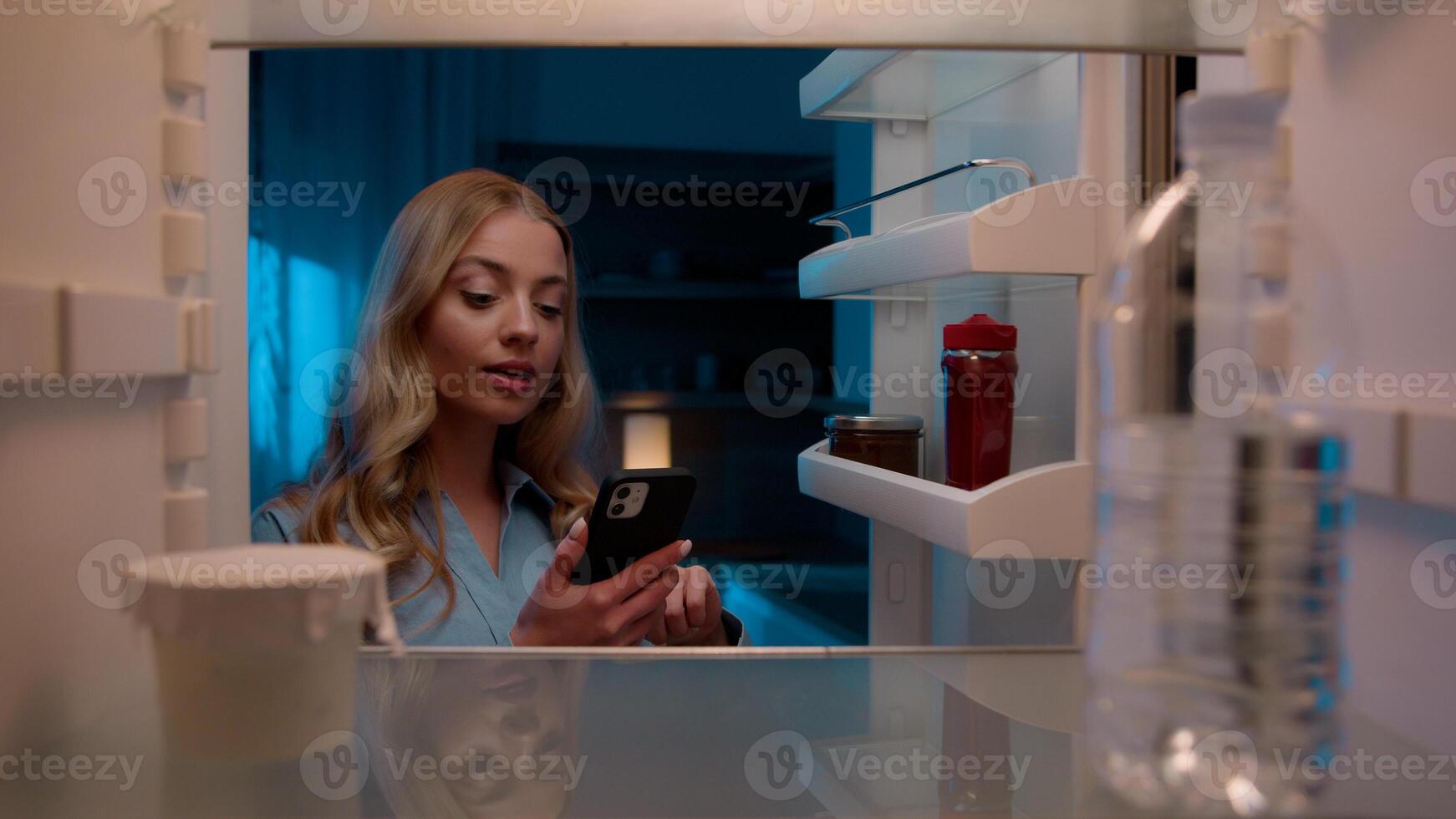Point of view POV inside refrigerator Caucasian girl hungry woman open fridge at home kitchen look at empty shelves order food products delivery with mobile phone app online service web store shopping photo