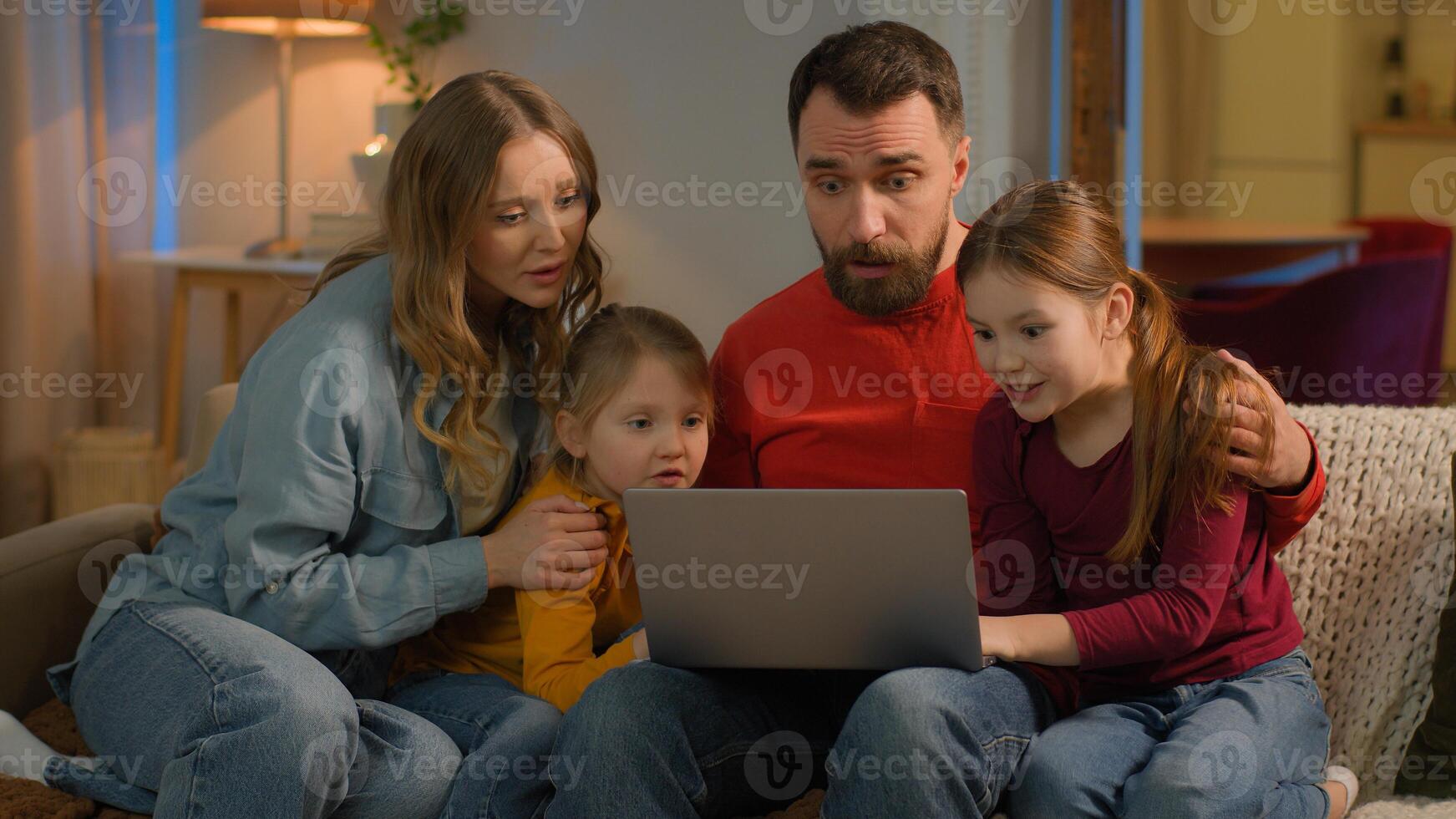 Family mother father children Caucasian parents kids little girls daughters on home couch evening weekend using laptop online shopping watch movie computer addict play game lose fail upset sad photo