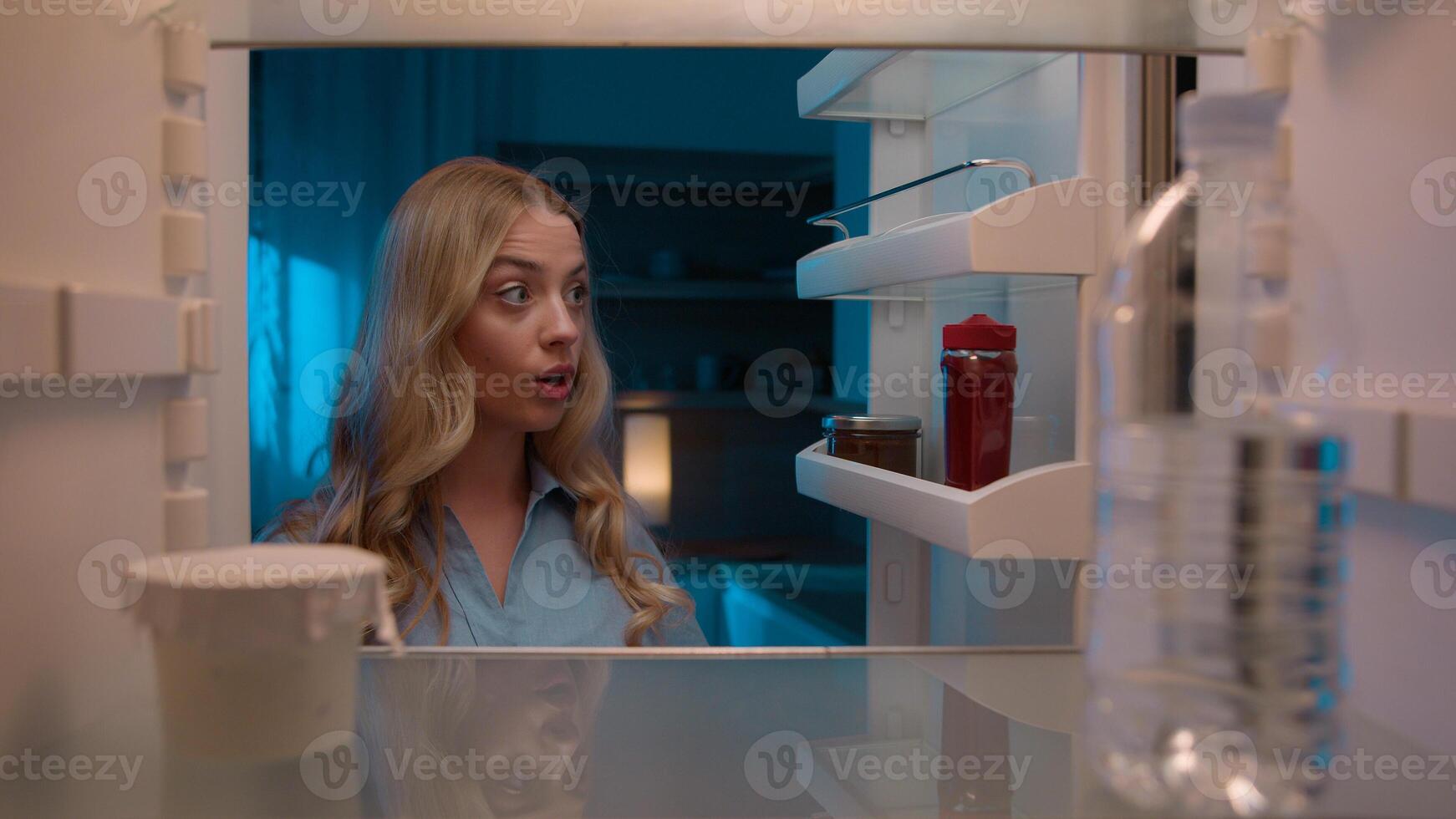 Point of view POV inside refrigerator Caucasian girl hungry woman open fridge at home kitchen look at empty shelves order food products delivery with mobile phone app online service web store shopping photo
