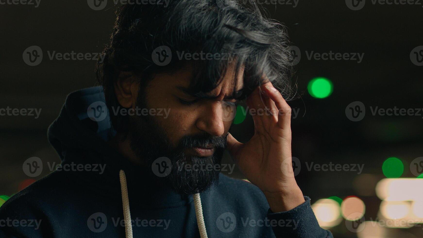 Close up stressed worried ill sick unhappy sad Arabian man touching painful head suffer headache pain unhealthy Indian guy male at parking suffering migraine cancer symptom tumor high blood pressure photo