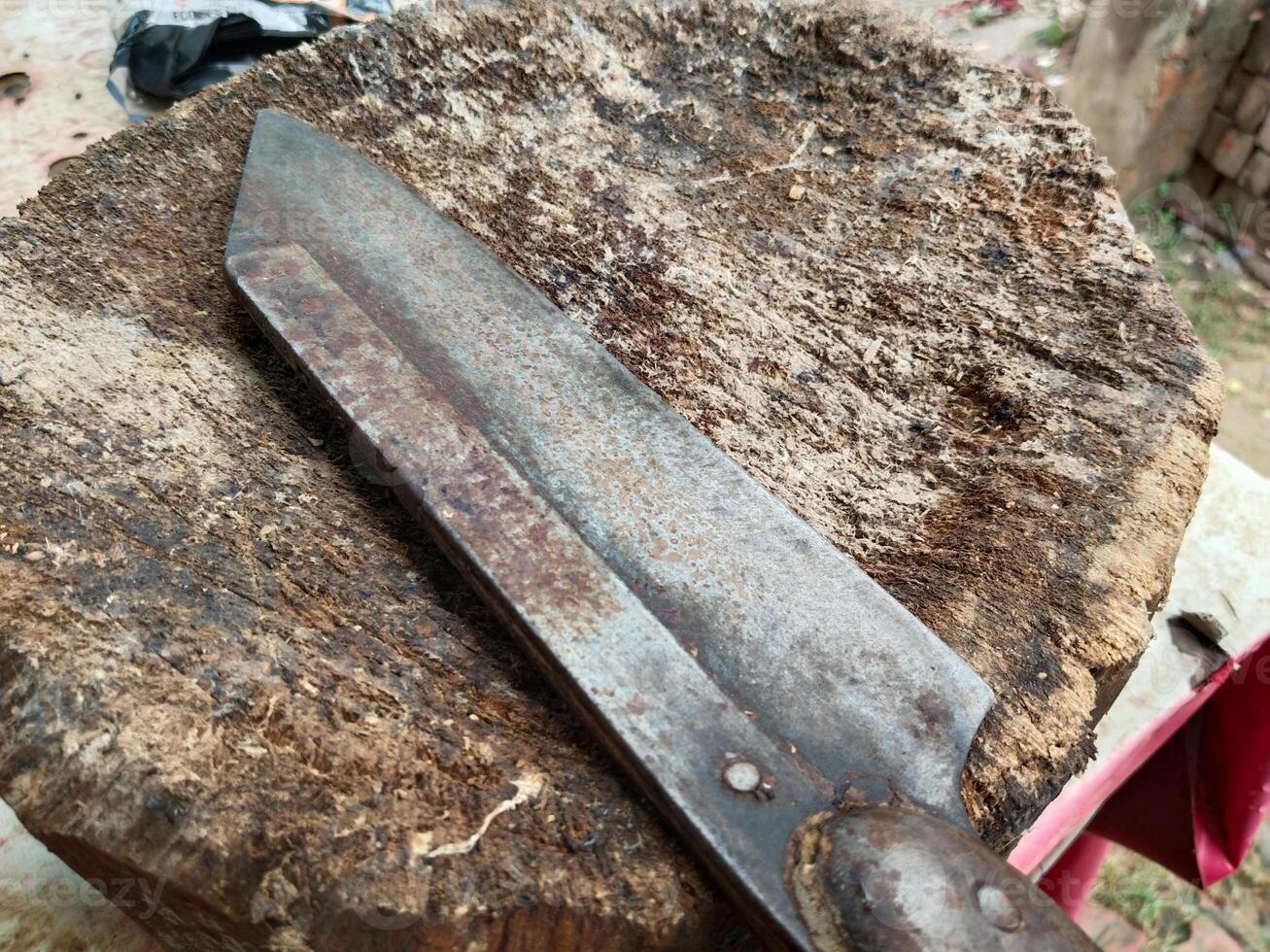 butcher knife and cleaver on a wooden block at a meat shop in an Asian market. A butcher block with knife and meat clove at a shop in India. photo