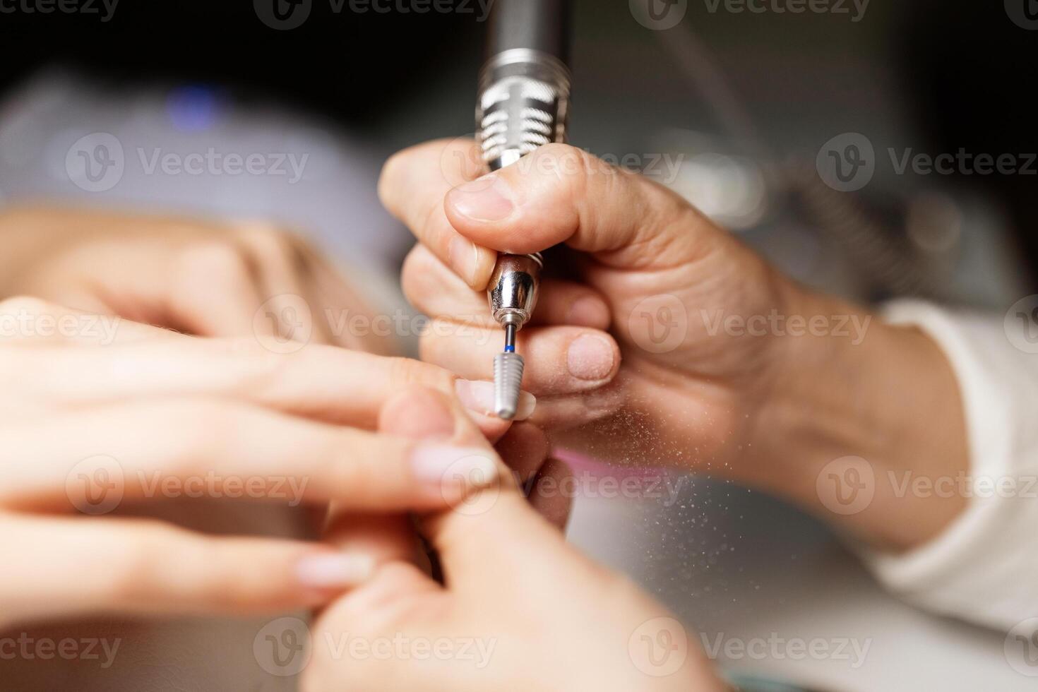 A skilled technician applies a vibrant nail polish while pampering a woman at a stylish salon. The atmosphere is relaxing, showcasing the latest nail trends and techniques. photo