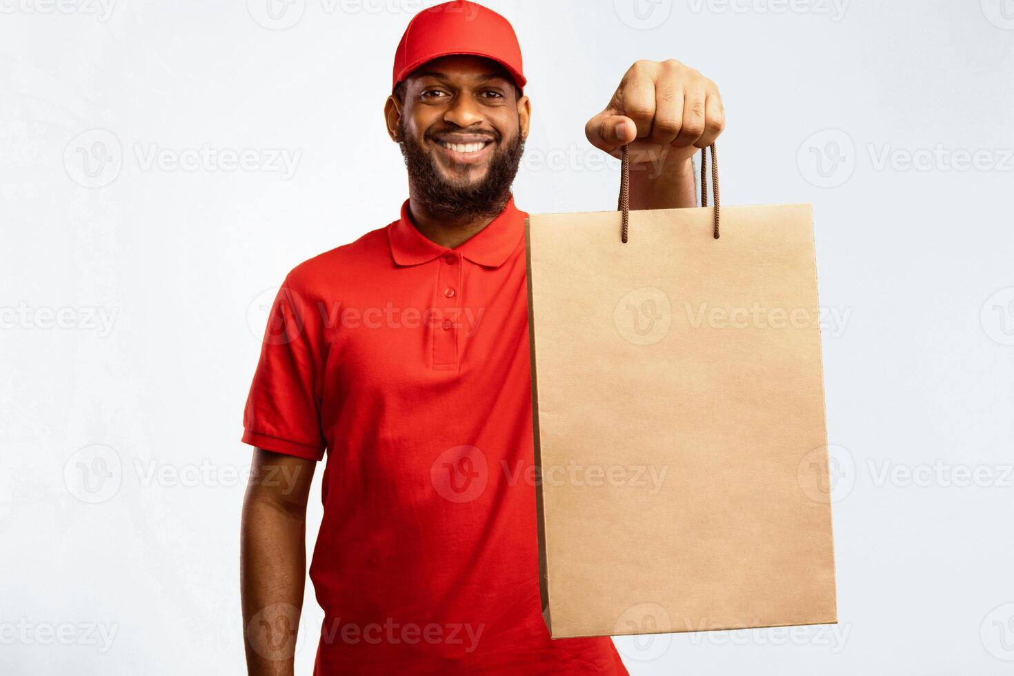 Online Shopping And Grocery Delivery Service. African Courier Giving Shopper Bag With Food Smiling To Camera On Yellow Studio Background. photo