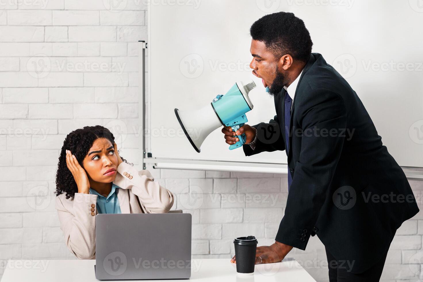 Furious boss with loudspeaker yelling at his female subordinate in office photo
