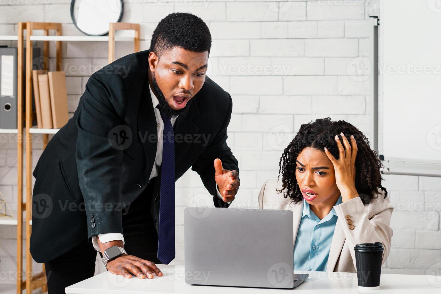 Stressed black woman with her male colleague finding error in work task or missing project deadline at workplace, panorama photo