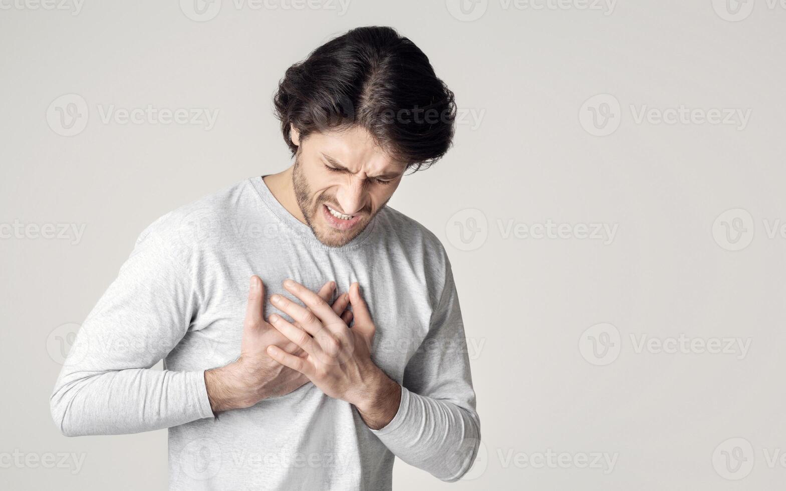 Healthcare concept. Man suffering from chest pain with painful expression photo