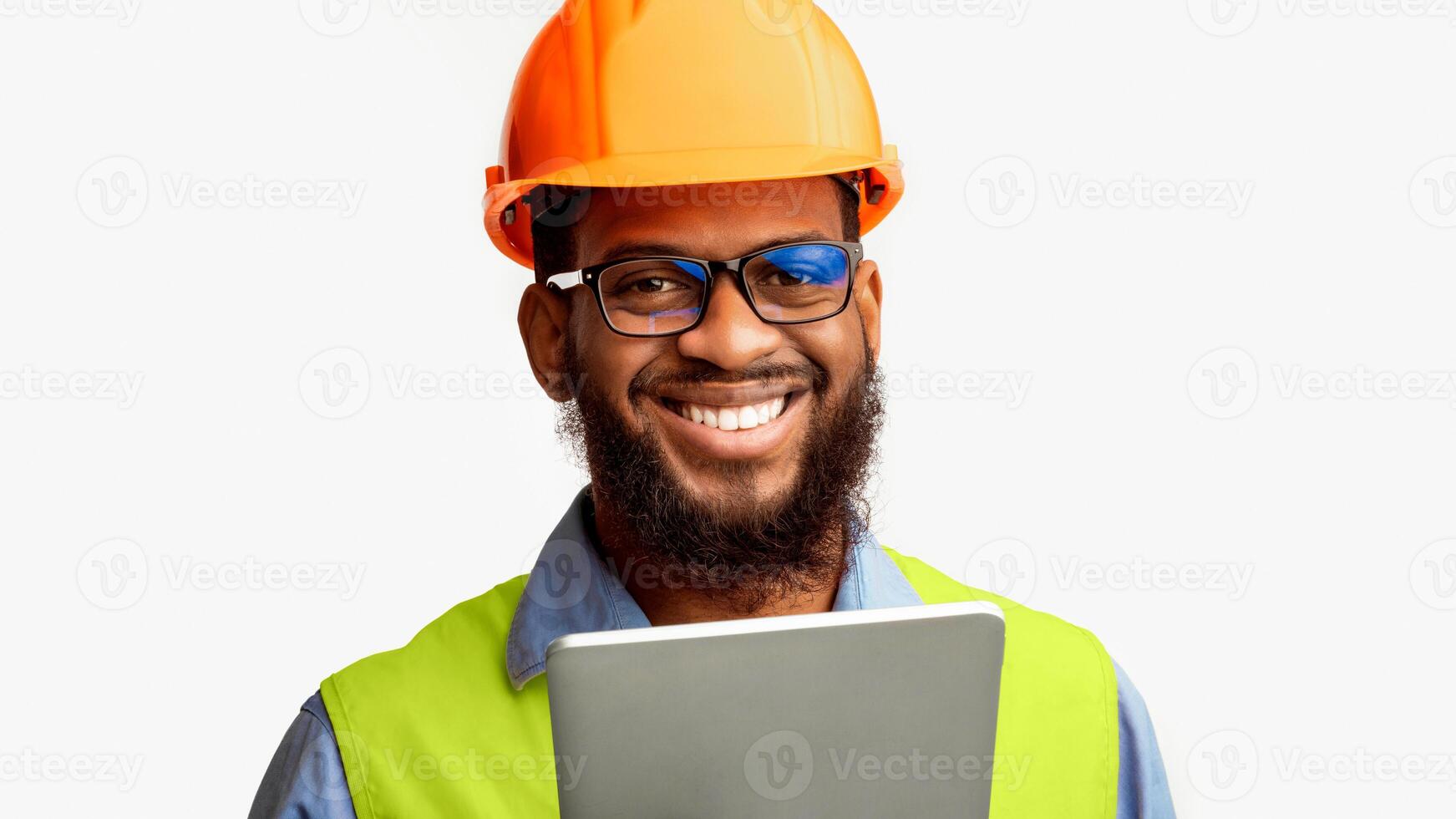 African Architect Man Using Tablet Computer Smiling To Camera Posing On White Studio Background, Wearing Construction Worker's Helmet And Vest. photo