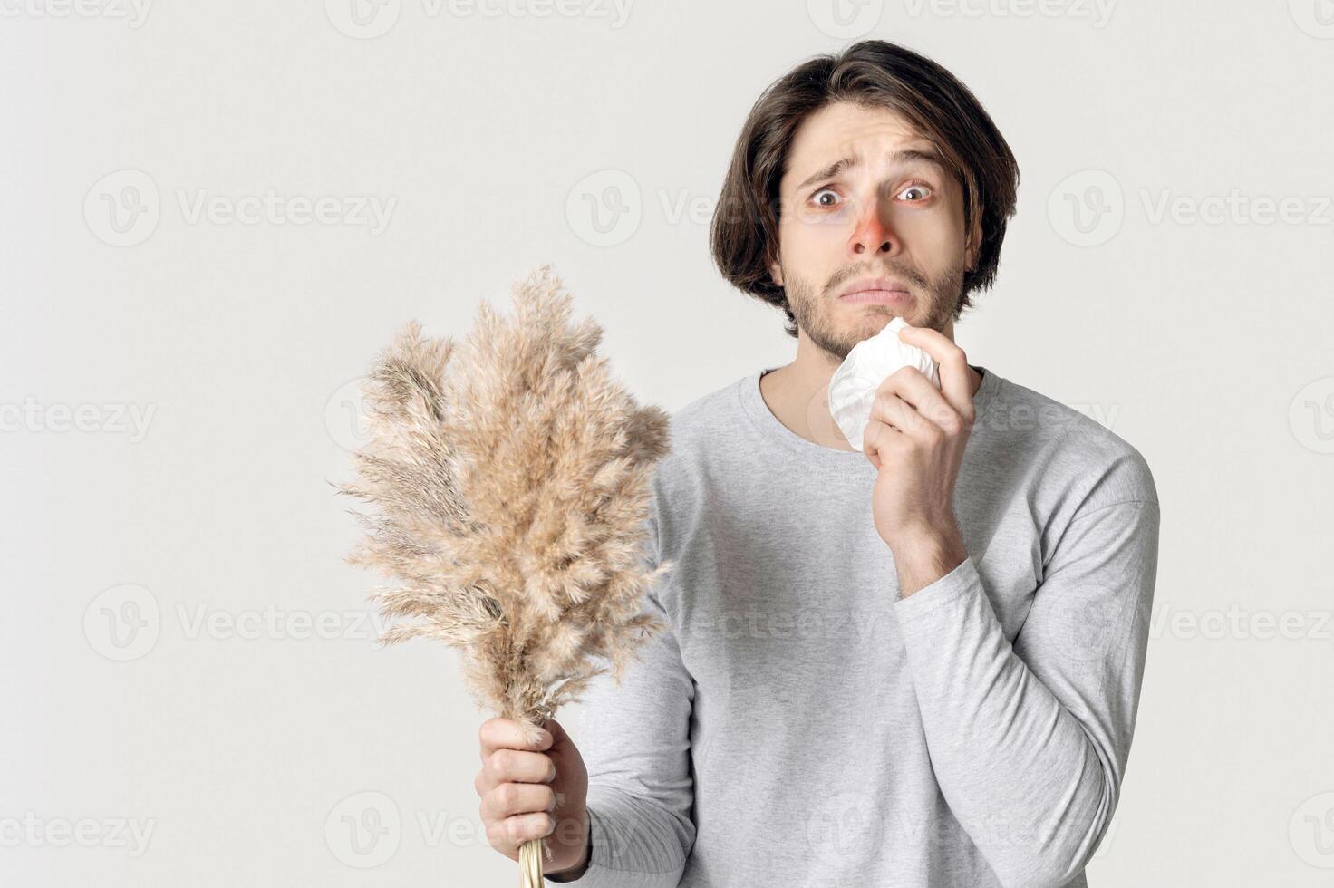 Allergy concept. Funny shocked man with red nose, napkin and bouquet photo