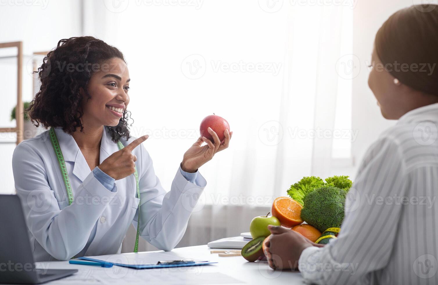 Pretty nutritionist black woman giving consultation to patient with Pretty nutritionist black woman giving consultation to patient with