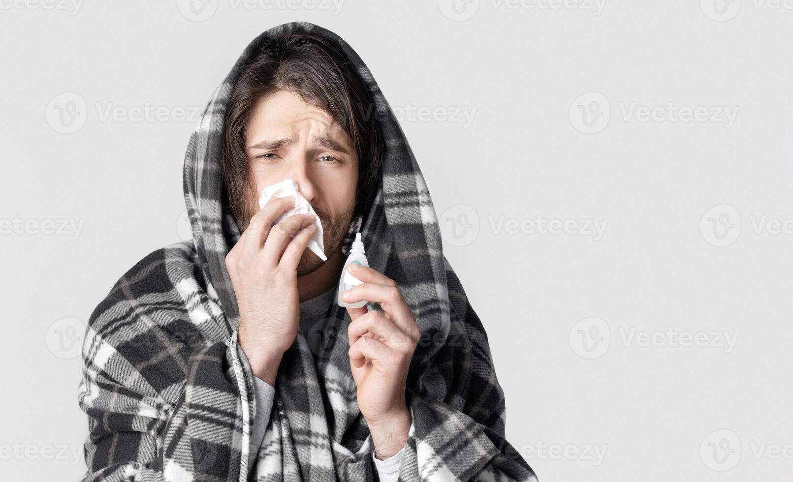 Cold symptoms and nose treatment concept. Man drips nose with spray photo