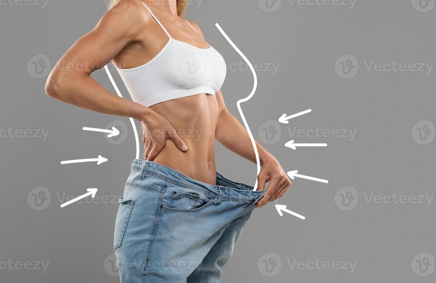 Young Slim Female Pulling Big Jeans And Showing Result Of Weight Loss With Drawn Silhouette Outlines And Arrows, Unrecognizable Sporty Woman In Oversized Clothes Demonstrating Body After Slimming photo
