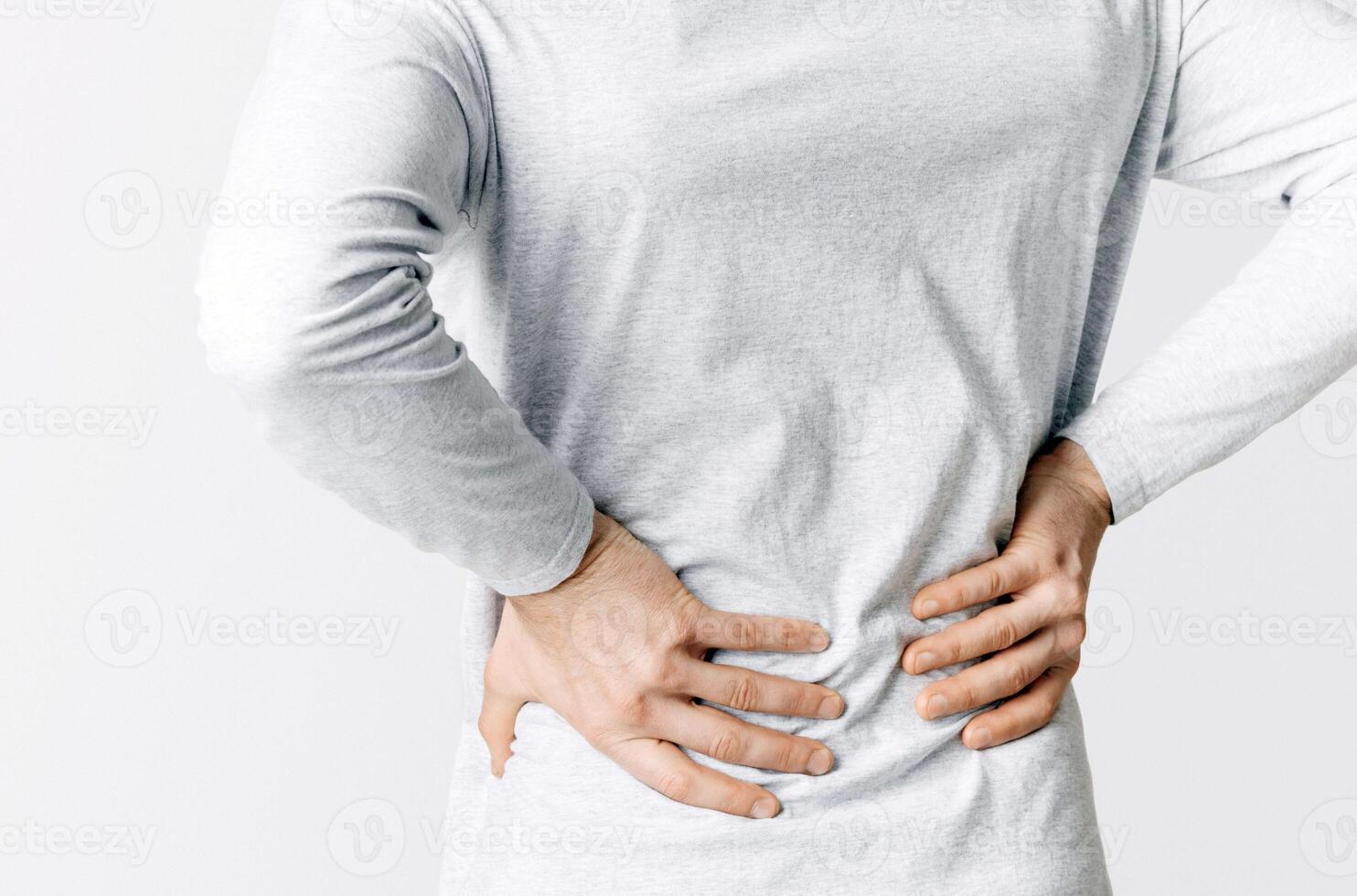 Renal colic and back pain. Man suffers from lower back pain, cropped, studio shot photo