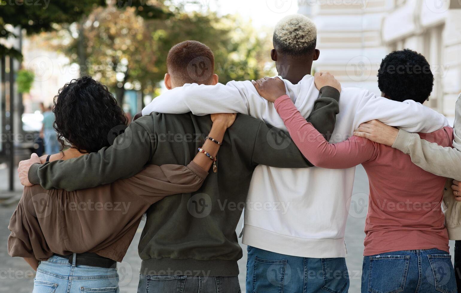 Back view of international group of people making strike on the street, hugging, showing their strong unity, demanding from government saving planet, reducing pollution. Riot, demonstration, strike photo