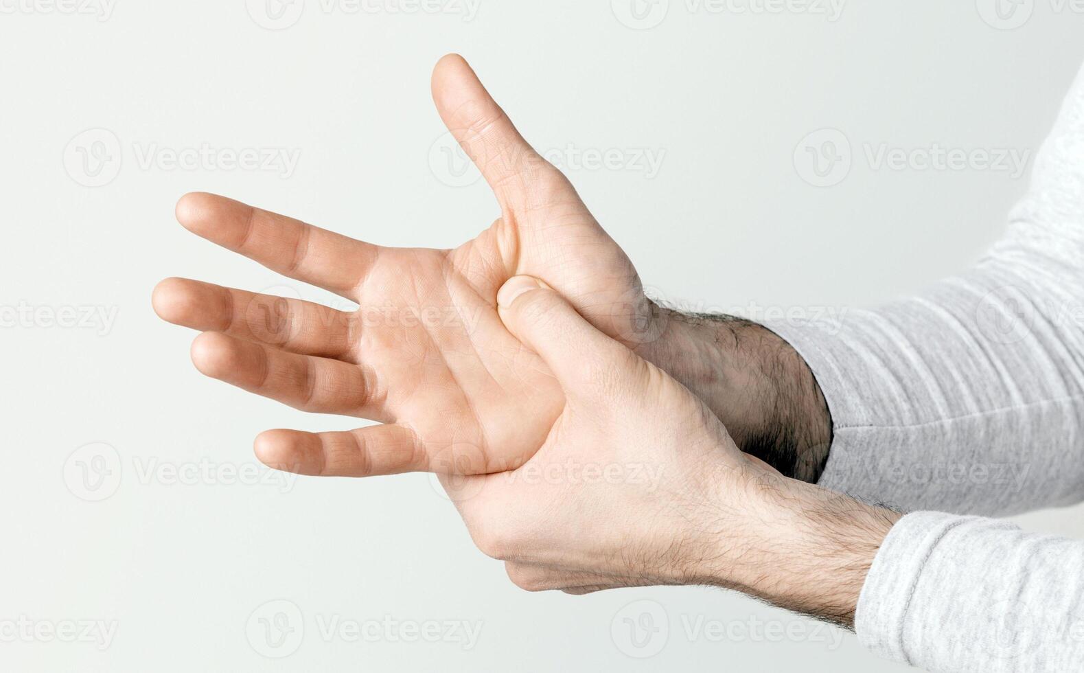 Body ache. Man presses his hand to hand in pain due to arthritis or injury, cropped, studio shot, close up photo