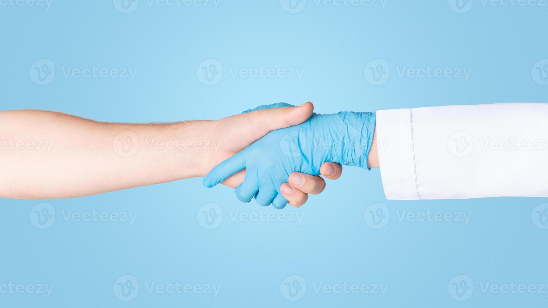 Closeup view of man shaking hands with doctor in rubber glove on white background photo