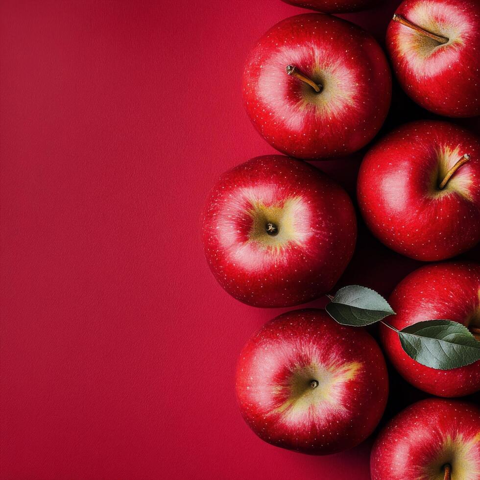 Fresh red apples arranged on a solid red background for a vibrant display of fruit photo