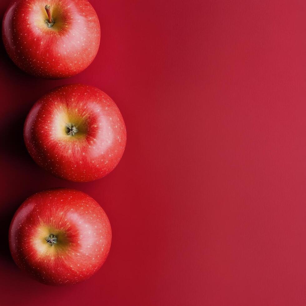 Fresh red apples arranged on a solid red background for a vibrant display of fruit photo