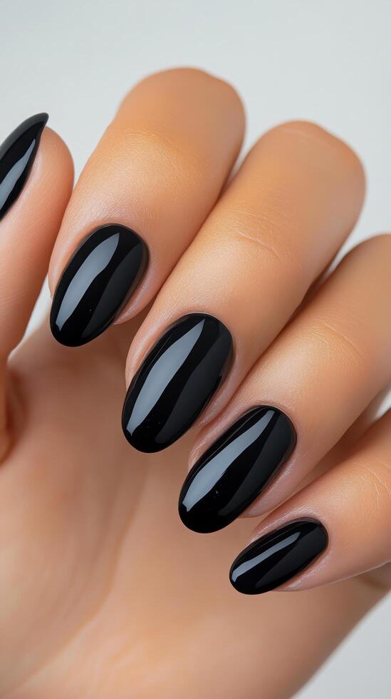Elegant black nail polish on well manicured hand showcasing stylish design and finish photo