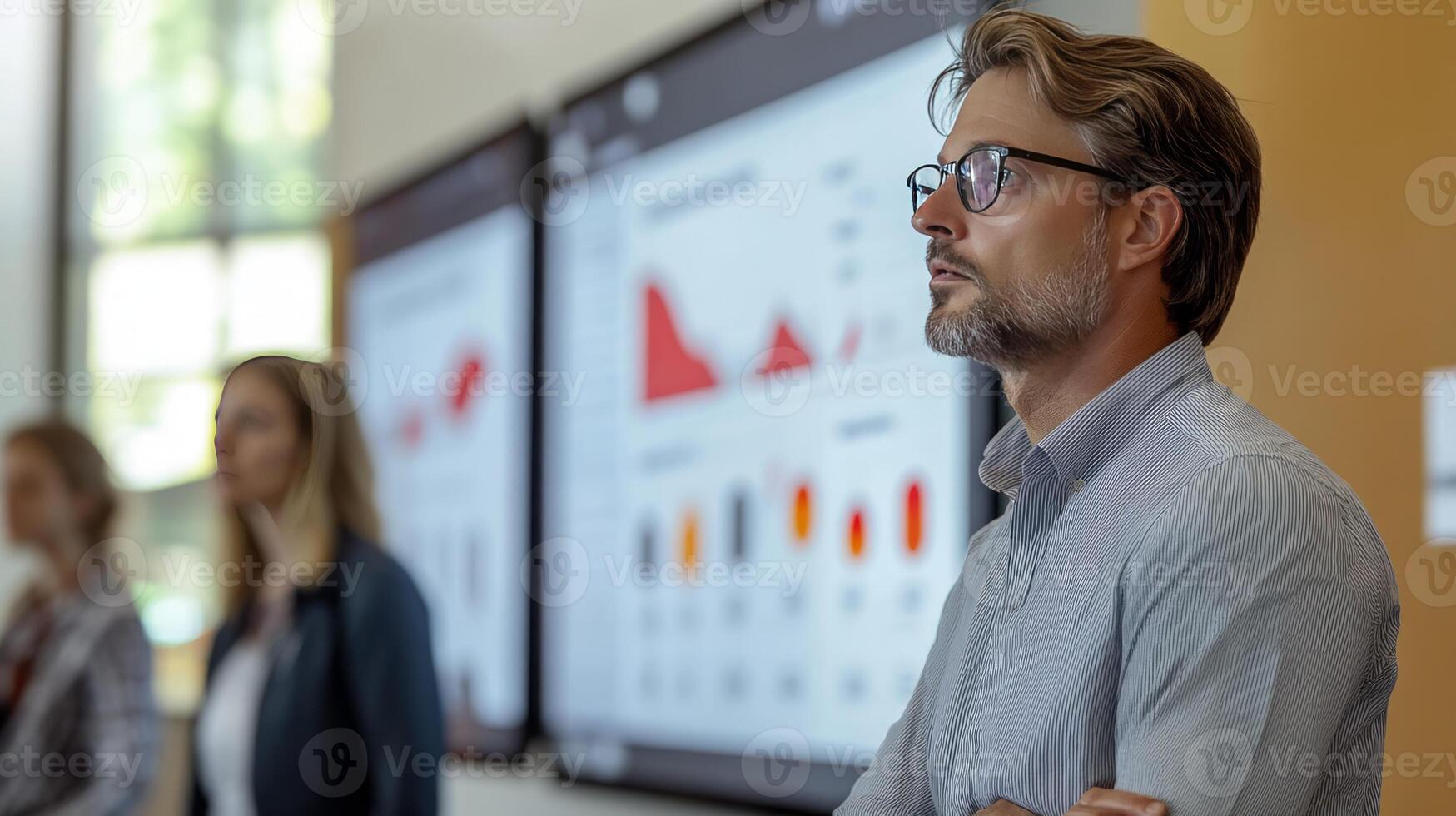 Man in glasses standing in front of a large screen photo
