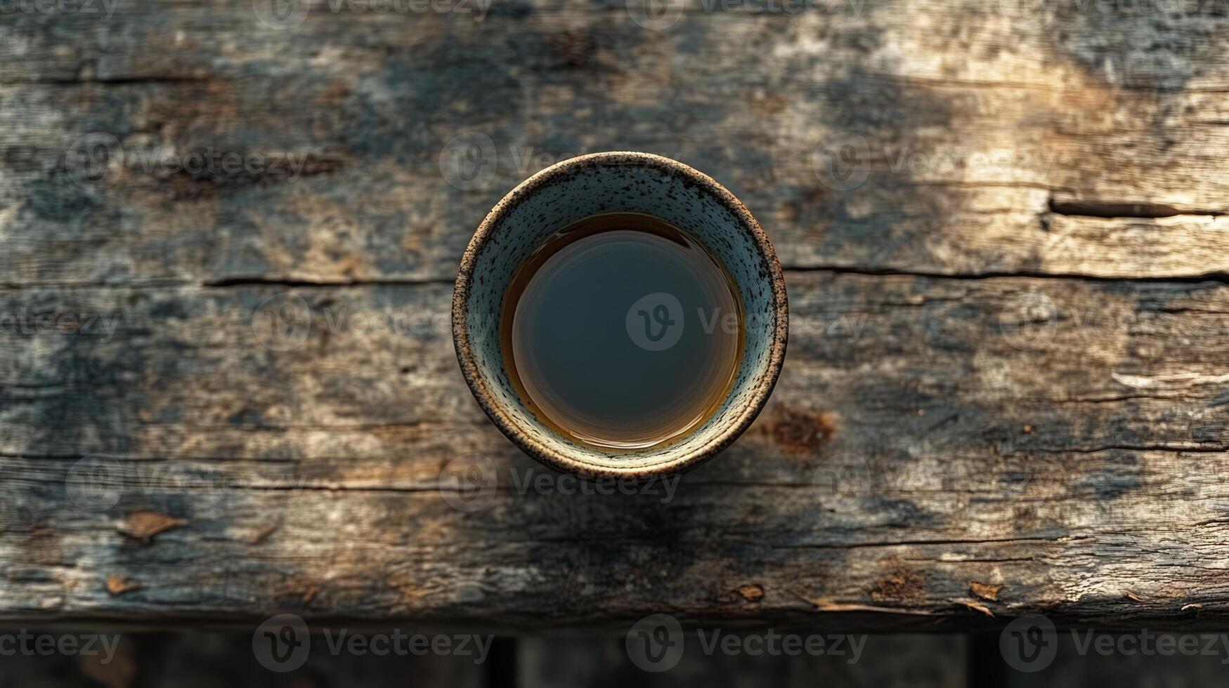 A cup of tea sits on top of a wooden table photo