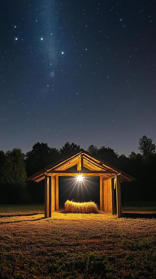 Starry night over a rustic shelter with hay under a glowing light in the countryside photo