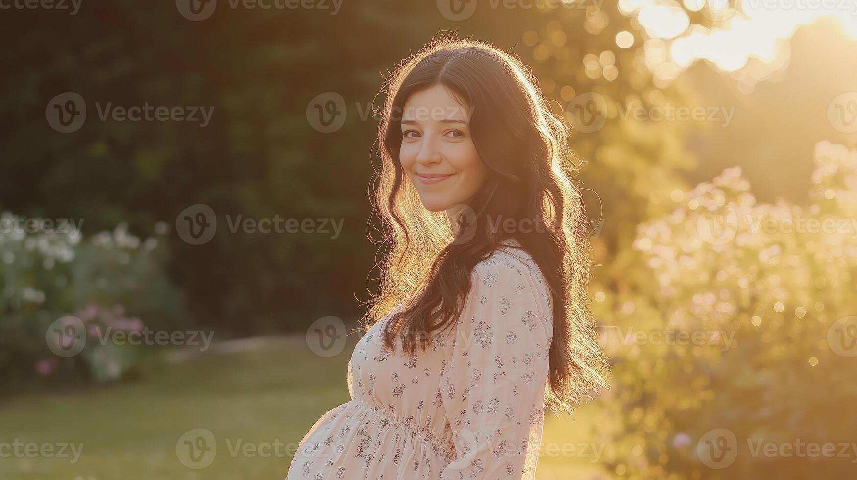 Southern european pregnant woman enjoying sunset in a garden setting for maternity and nature themes photo