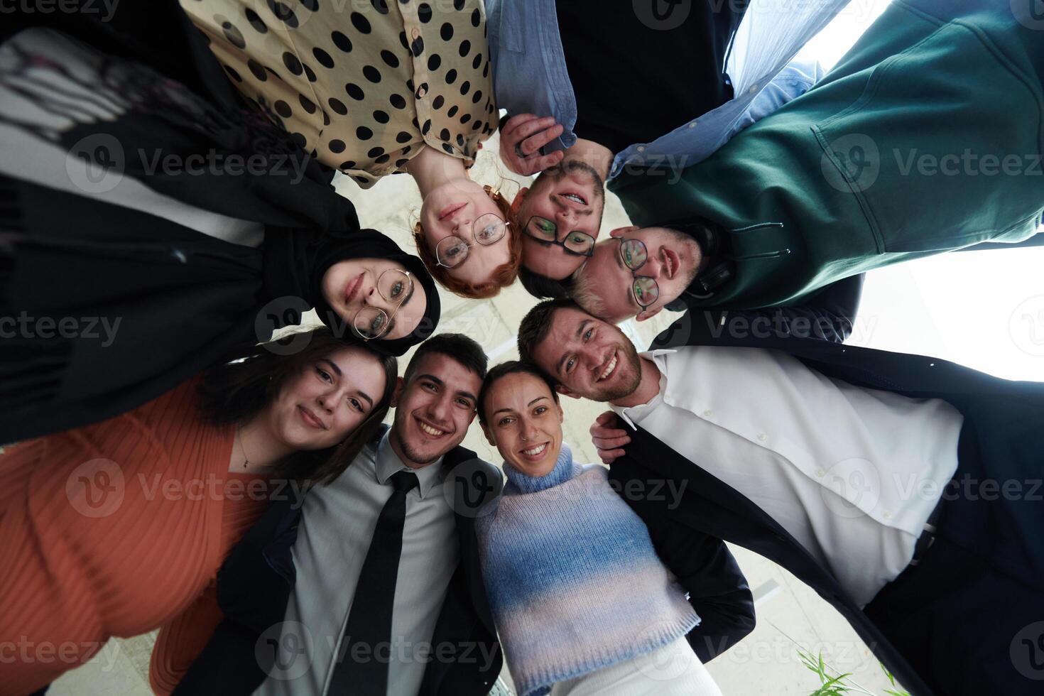 A diverse group of business professionals standing together in a powerful, united pose, captured from a low-angle perspective, exuding confidence and teamwork photo
