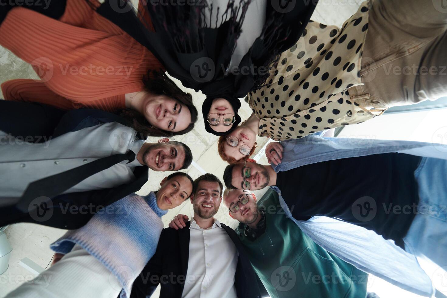A diverse group of business professionals standing together in a powerful, united pose, captured from a low-angle perspective, exuding confidence and teamwork photo