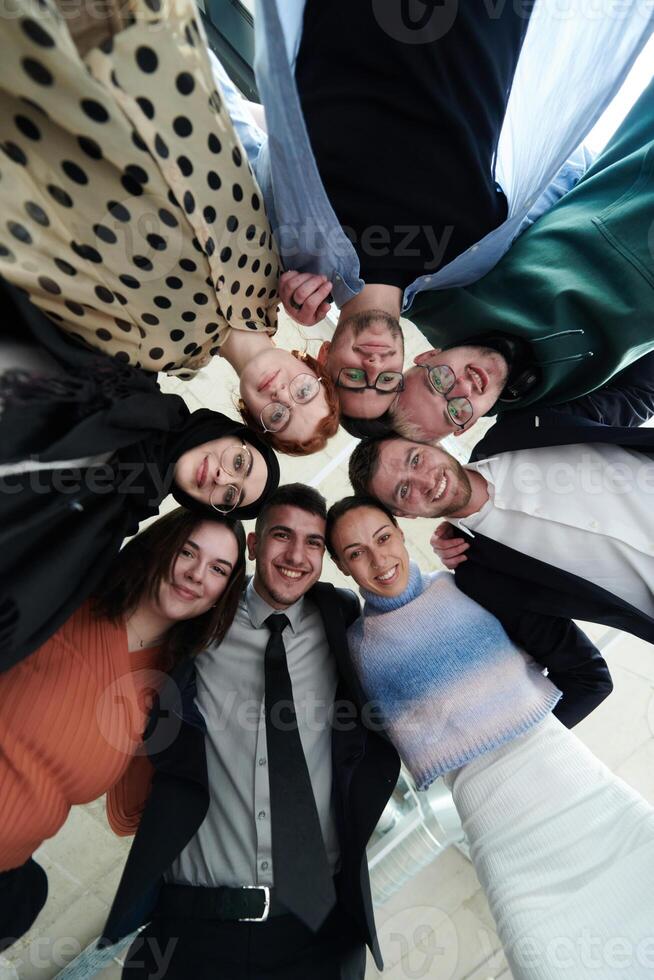 A diverse group of business professionals standing together in a powerful, united pose, captured from a low-angle perspective, exuding confidence and teamwork photo