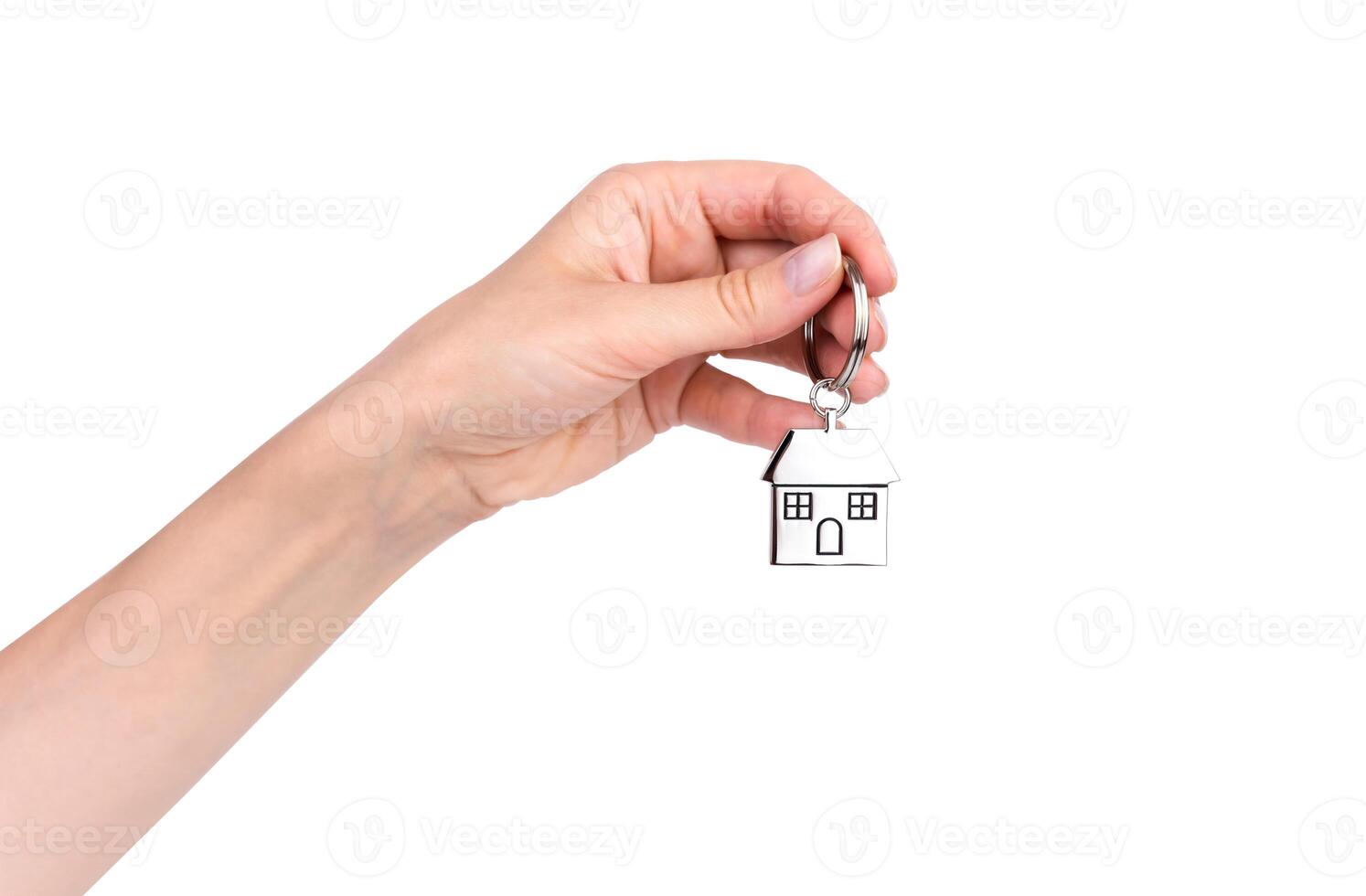 Woman's hand holds the keychain with house isolated on white background. Purchase or rent of apartments. photo