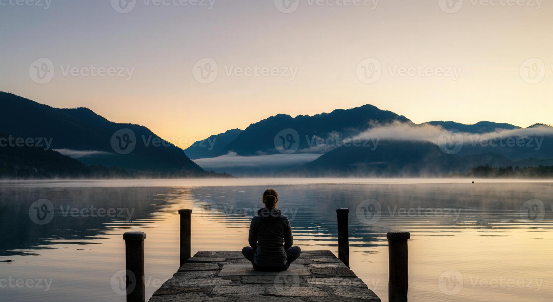 Peaceful meditation at dawn on a serene lake dock with scenic mountain views photo
