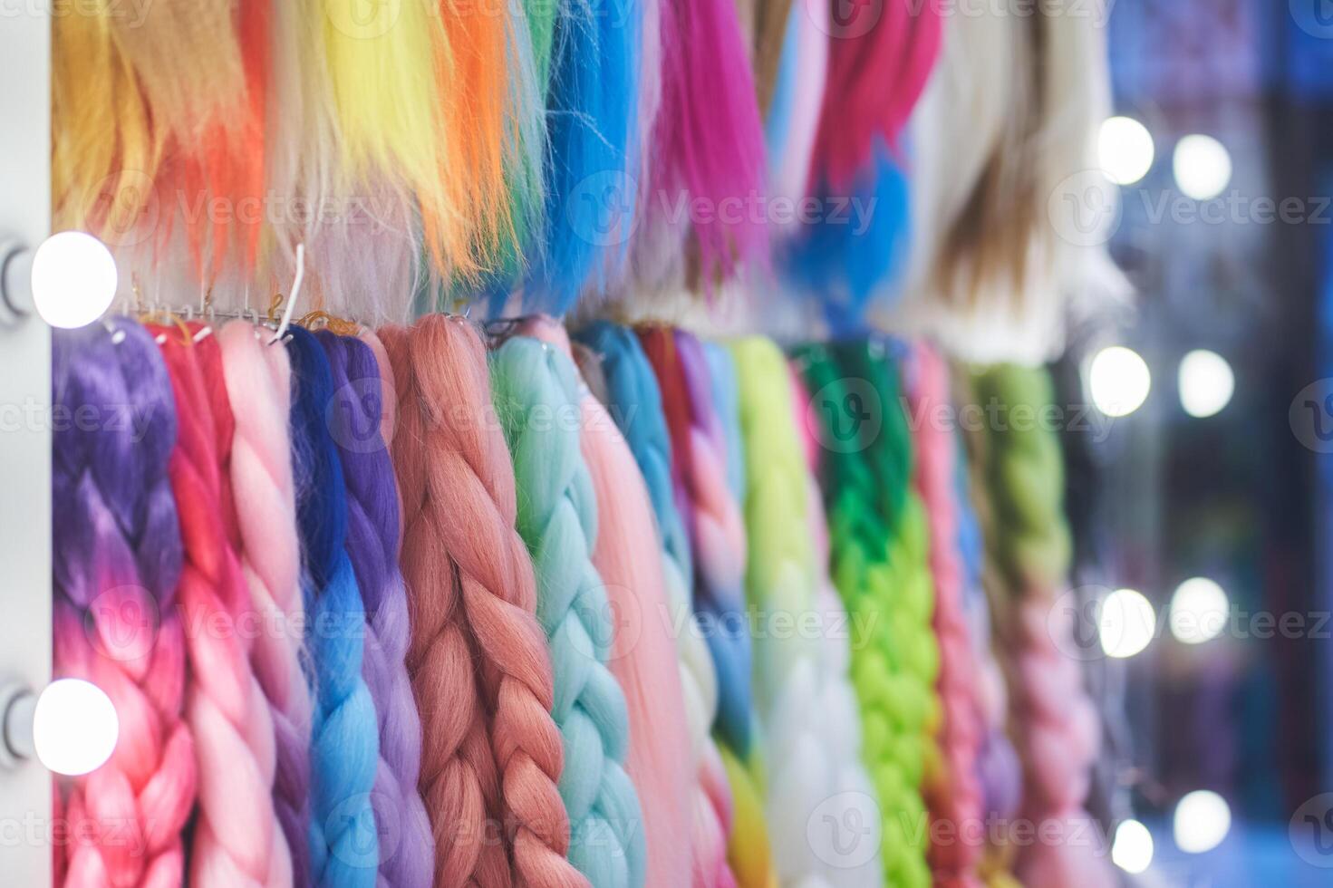 Artificial material for braiding pigtails. A colored kanekalon hangs on the wall, different materials for Afro-pigtails with space for copying photo
