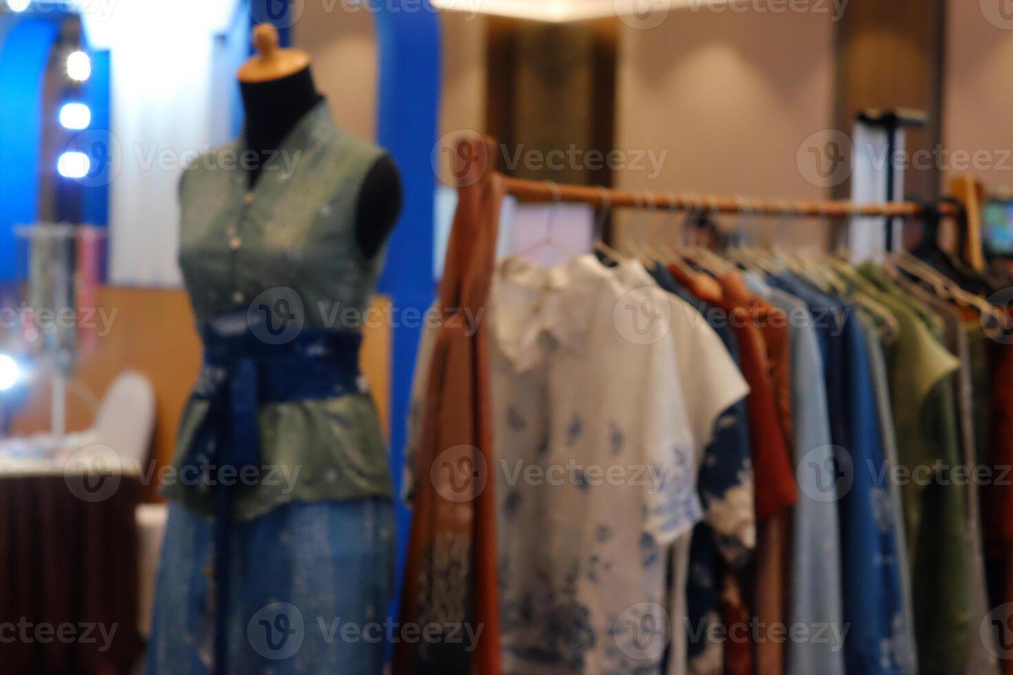 An array of Indonesian batik shirts and batik cloth hangs on the racks, displaying a variety of patterns and colors. photo