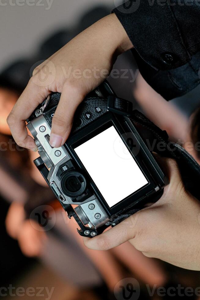 A person's hand holding a DSLR camera, as a camera mockup displays photography skills and creative potential in various settings. photo