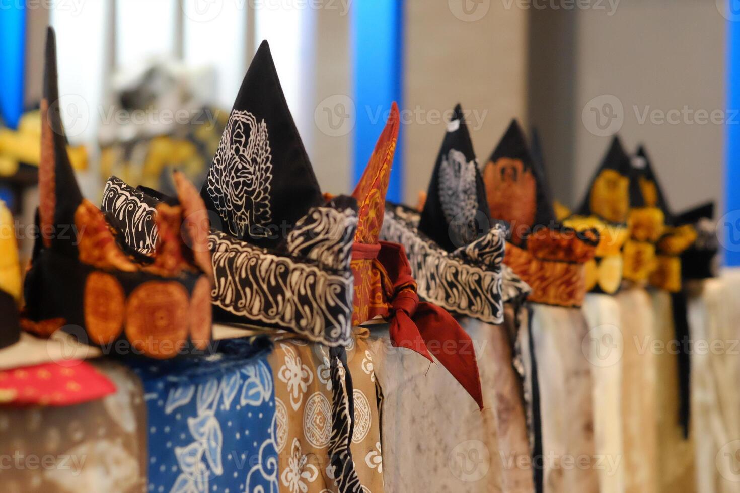 An array of Indonesian batik shirts and batik cloth hangs on the racks, displaying a variety of patterns and colors. photo