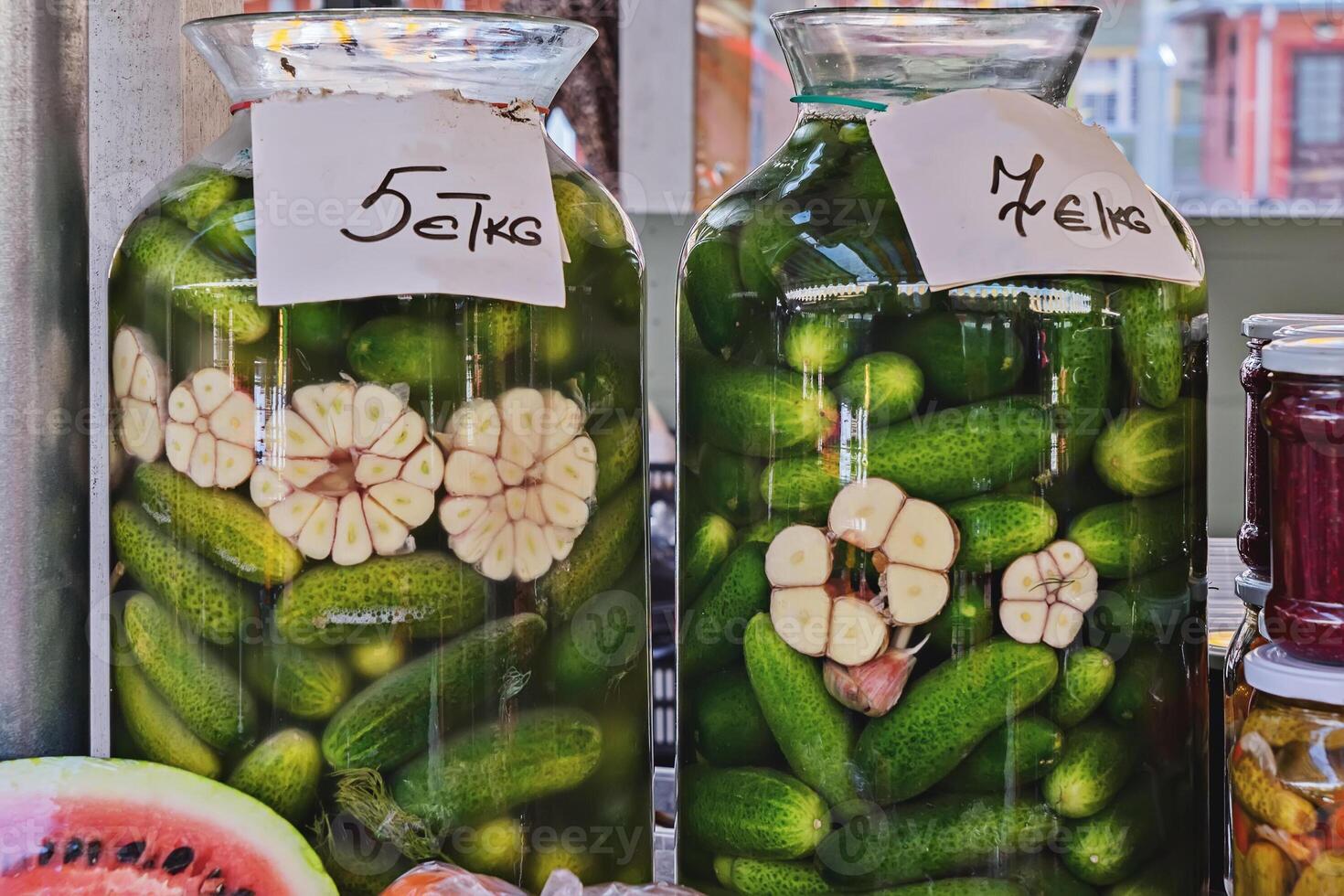 Pickled cucumbers in jars with garlic at a farm market. photo