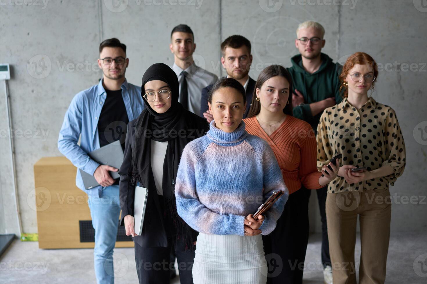 A diverse and determined team of business professionals stands confidently in an office, ready to tackle new business plans and challenges with a focus on success and growth photo