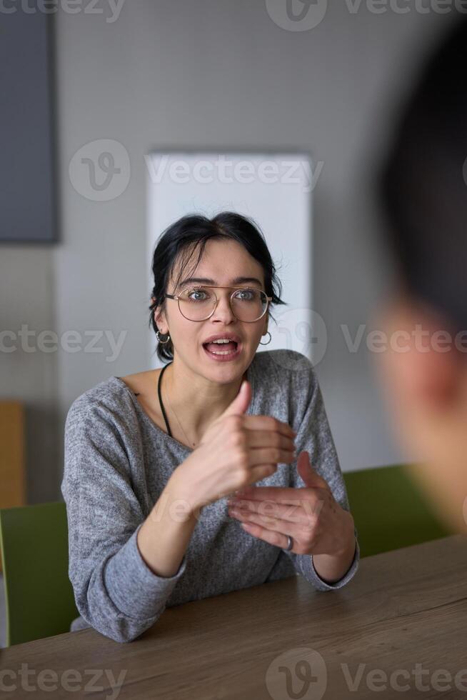 A close up portrait of a young businesswoman engaged in a professional meeting, confidently discussing ideas and strategies with her colleagues photo