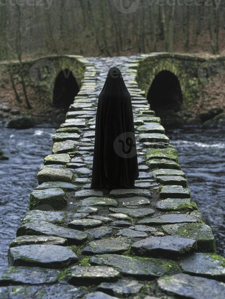 Mysterious figure in dark cloak on mossy stone bridge photo