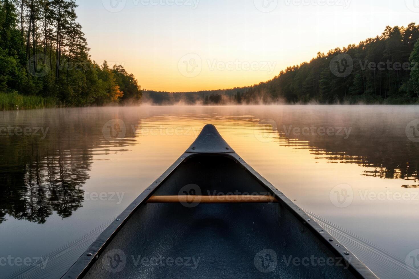 Serene lake at sunset with a canoe in the foreground photo
