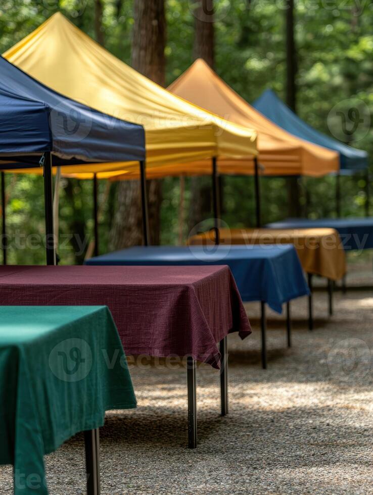 Colorful tents and tables in a wooded outdoor market setting photo