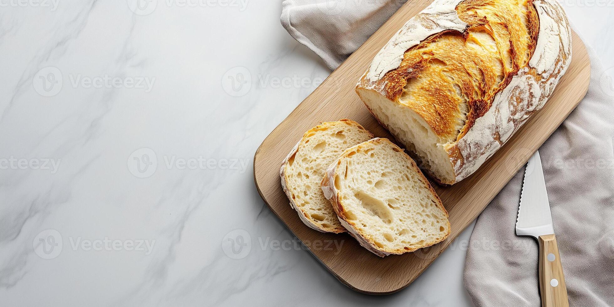 Sliced ciabatta loaf on a flat surface with a knife nearby, food setting photo