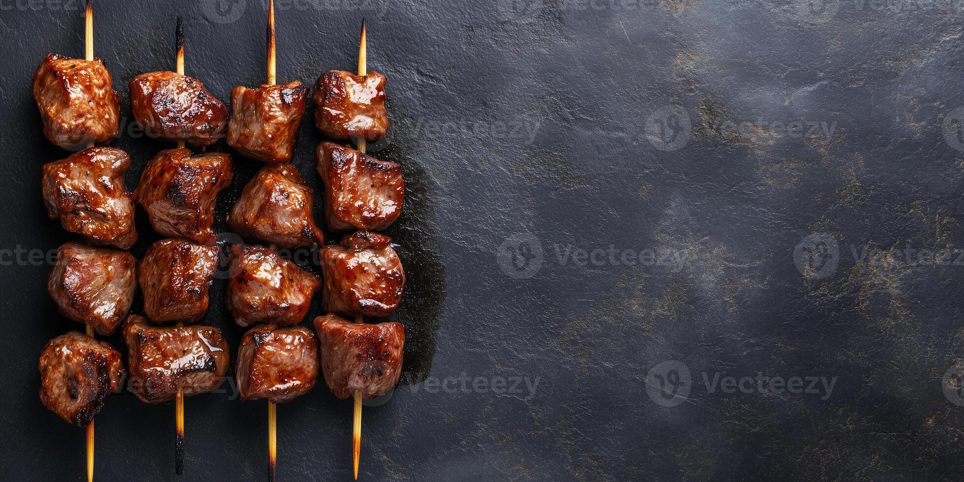 Grilled meat chunks on a skewer, lying horizontally on a flat surface, food setting photo